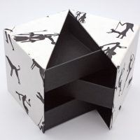 Caja forma de cubo y apertura de concha, papel natural decorado con figuras rupestres, el Telar encuadernación